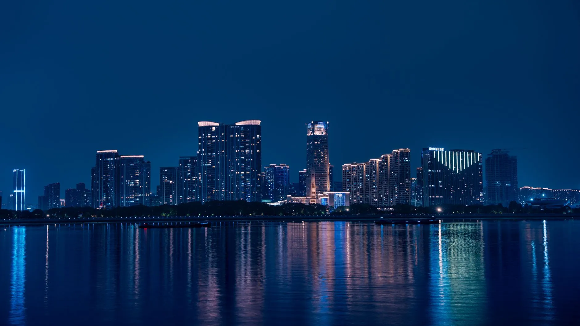 Captivating view of Hangzhou's skyline reflecting on Qiantang River at night.