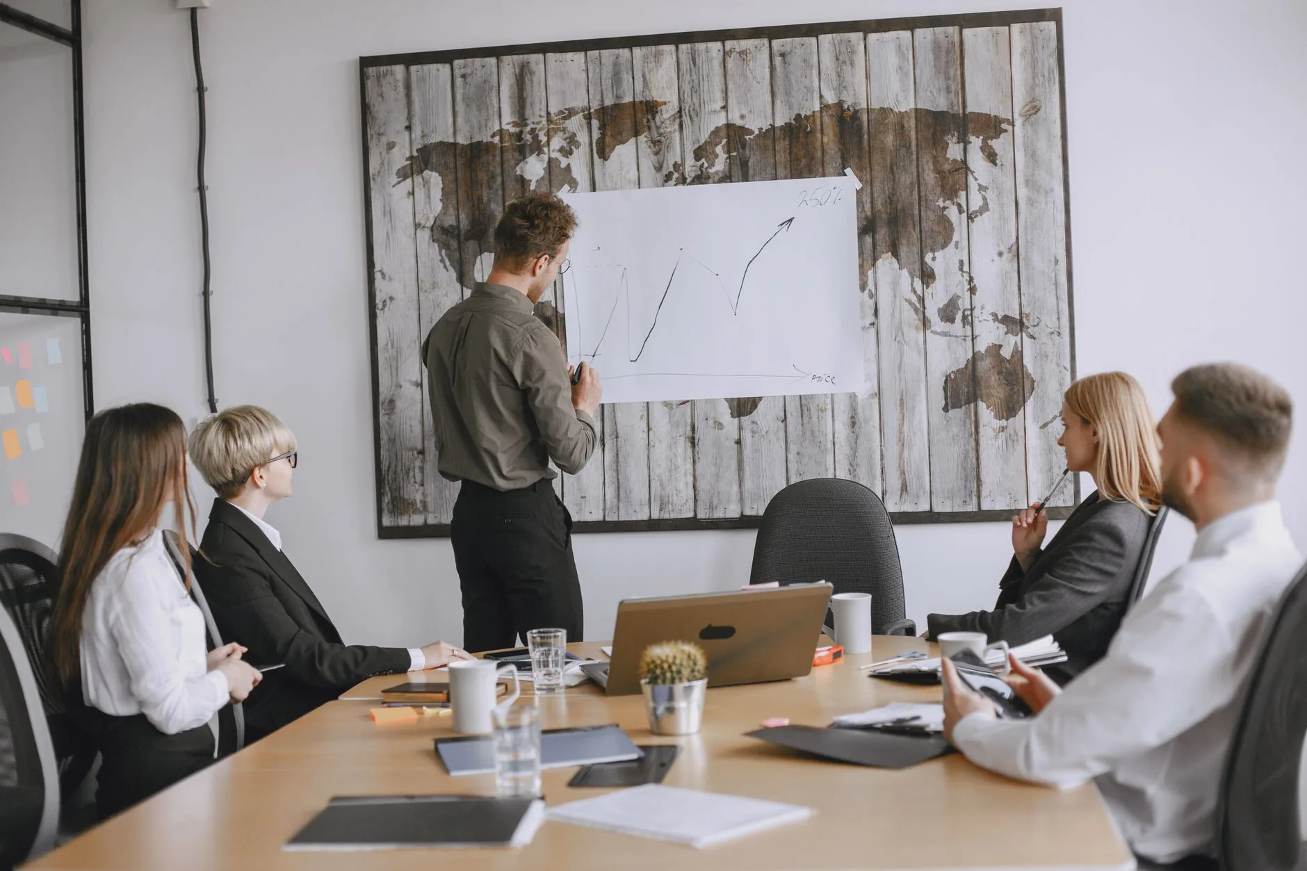 Group of business professionals discussing strategies with growth chart in conference room.